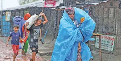  ??  ?? People make their way to a safer place before the cyclone Amphan makes its landfall in Gabura outskirts of Satkhira district,
Bangladesh on May 20, 2020.