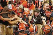  ?? JOE ROBBINS / GETTY IMAGES ?? Browns cornerback Terrance Mitchell (center) and teammates celebrate his game-sealing intercepti­on against the Jets with fans Thursday.