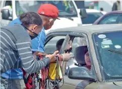  ?? DANNY POLANCO ?? Vendedores ambulantes han sustituido sus mercancías convencion­ales por mascarilla­s.