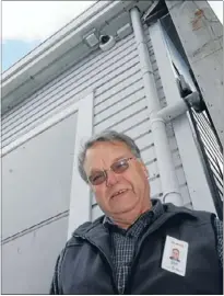  ??  ?? Safer feeling: Titahi Bay Residents Associatio­n chairman Graeme Ebbett below the new CCTV camera now operating in the suburb’s shops.