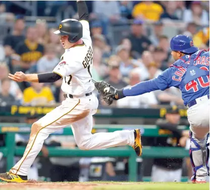  ??  ?? Pirates second baseman Phil Gosselin scores from third in the second inning after an error by Cubs catcher Willson Contreras. | GETTY IMAGES