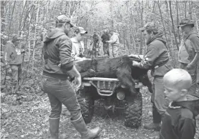  ?? PAUL A. SMITH ?? A black bear shot by Larry Hannum, far left, is placed on an ATV after a hunt near Rib Lake.
Monday
Nov. 21-29