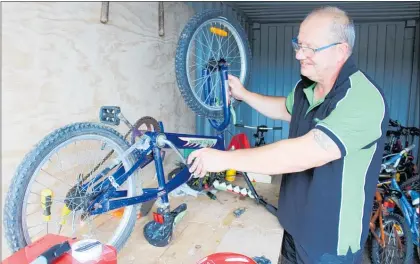  ?? PHOTO / ROSALIE WILLIS ?? Phil Byrne fixing up a bike for
O¯ taki Bike Space.