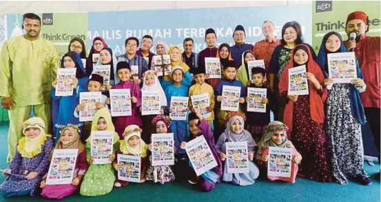  ?? (FOTO SHAHNAZ FAZLIE SHAHRIZAL) ?? Encik Zawawi Yusop (tengah barisan belakang) bersama-sama murid Sekolah Kebangsaan Tanjung Tokong dan Tadika Ar-rasyiddin sambil menunjukka­n buku Think Green di Tanjung Tokong, Pulau Pinang.