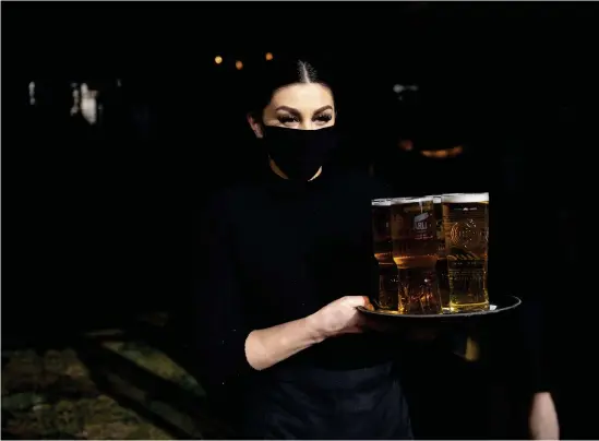  ?? Bild: Jacob KING/AP/TT ?? Öl på väg ut till besökare på puben Figure of Eights uteserveri­ng i Birmingham strax efter midnatt på måndagen.