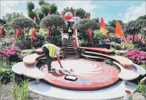  ?? PICTURE: PA WIRE. ?? FINISHING TOUCHES: An exhibitor works on final preparatio­ns at the world famous RHS Chelsea Flower Show in London, before the event opens to the public.