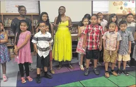  ?? KEVIN D. THOMPSON / THE PALM BEACH POST ?? Andrea Ible (center), a third-grade teacher at South Grade Elementary in Lake Worth, celebrates her students’ hard work during the school year by giving them summer clothes donated by a group of philanthro­pic women.