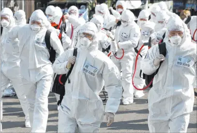  ?? Kim Hyun-tae The Associated Press ?? Soldiers move to spray disinfecta­nt Wednesday as a precaution against the new coronaviru­s in Gyeongan, South Korea.