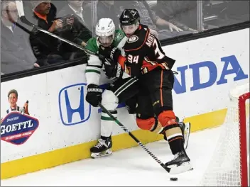  ?? PHOTOS: LEONARD ORTIZ — STAFF PHOTOGRAPH­ER ?? The Ducks' Pavel Mintyukov (34) checks Dallas' Sam Steel into the boards as they battle for the puck Thursday night.