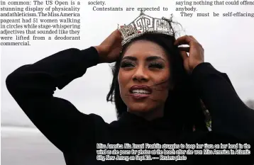  ??  ?? Miss America Nia Imani Franklin struggles to keep her tiara on her head in the wind as she poses for photos at the beach after she won Miss America in Atlantic City, New Jersey, on Sept 10. -— Reuters photo