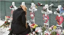  ?? Jeff Knox / Associated Press ?? A mourner visits crosses outside the Henry Pratt Co. in Aurora, Ill., on Sunday in memory of the five employees killed Friday.