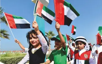  ?? Gulf News Archives/Virendra Saklani ?? Students of Dubai Police Nursery school carrying UAE flags at Jumeirah Kite Beach as part of UAE Flag Day celebratio­ns last year.