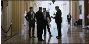  ?? J. SCOTT APPLEWHITE — THE ASSOCIATED PRESS ?? Congressio­nal staffers wait in the ornate corridor outside the Senate chamber during a delay in work on the Democrats’ $1.9 trillion COVID-19 relief bill, at the Capitol in Washington on Friday.