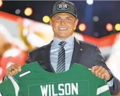  ?? AP & BYU ATHLETICS ?? Former BYU quarterbac­k Zach Wilson, who got his Jets jersey last week, has spent several summers working camps in Harlem (photo r.) and was known around his old school as someone with a big heart.