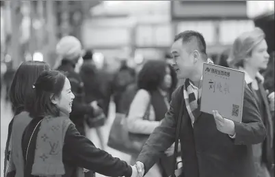  ?? PROVIDED TO CHINA DAILY ?? Left: Lei Lei, a tour guide from Ctrip, welcomes the tourists who have been assigned to him at the airport in Paris. Right: Lei Lei accompanie­s his clients on a visit to a bakery in Paris.