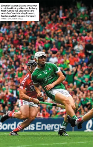  ?? RAMSEY CARDY/SPORTSFILE ?? Limerick’s Aaron Gillane kicks over a point as Cork goalkeeper Anthony Nash rushes out. Gillane was the semi-final’s outstandin­g forward, finishing with five points from play