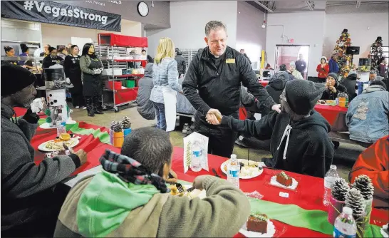  ??  ?? ABOVE: Catholic Charities of Southern Nevada President and CEO Deacon Thomas A. Roberts greets guests during Christmas dinner on Monday at Catholic Charities’ St. Vincent facility.
LEFT: Sharonda Hightower and her 2-year-old son Ezra, who are...
