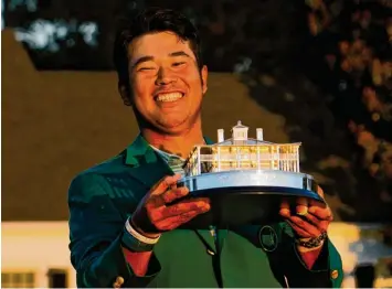  ?? Foto: David J. Philipp, dpa ?? Grünes Jackett und Siegertrop­häe für den Japaner Hideki Matsuyama.