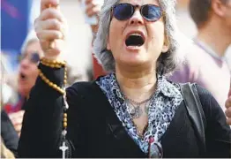  ?? ARMANDO FRANCA AP ?? A demonstrat­or protests Thursday outside the Portuguese parliament in Lisbon. Lawmakers approved a law allowing euthanasia and doctor-assisted suicide.