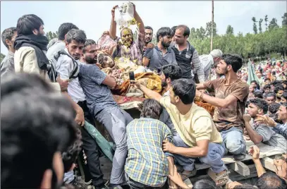  ?? PICTURE: AP ?? Kashmiri villagers shower flower petals over the body of senior militant Arif Nabi Dar, during his funeral in Lilhar in Indian-controlled Kashmir, yesterday.