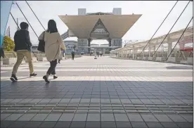 ?? (AP/Hiro Komae) ?? People walk towards the Tokyo Internatio­nal Exhibition Center, also known as Tokyo Big Sight. The exhibition center is a planned venue for the Tokyo 2020 Olympic and Paralympic Games, reschedule­d to start in July 2021.