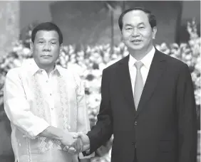  ?? GMA NEWS/AFP PHOTO ?? President Rodrigo Duterte (L) shakes hands with his Vietnamese counterpar­t President Tran Dai Quang (R) at the Presidenti­al Palace in Hanoi. Duterte yesterday started the second day of his official visit to Vietnam with a meeting with Quang, The...