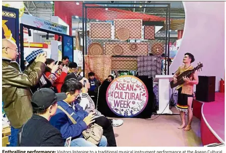  ??  ?? Enthrallin­g performanc­e: Visitors listening to a traditiona­l musical instrument performanc­e at the Asean Cultural Week 2018 in Beijing, China.