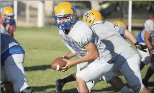  ??  ?? Brawley Union High’s quarterbac­k Casey Kline looks to hand off the ball to a teammate during their team practice in Brawley on Tuesday evening. VINCENT OSUNA PHOTO