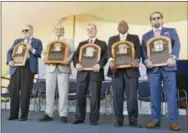  ?? HANS PENNIAK — THE ASSOCIATED PRESS ?? Newly-inducted National Baseball Hall of Famers from left, Bud Selig, Ivan Rodriguez, John Schuer, Tim RainesÂ Sr., and Jeff Bagwell hold their plaques after Sunday’s induction ceremony in Cooperstow­n, N.Y.
