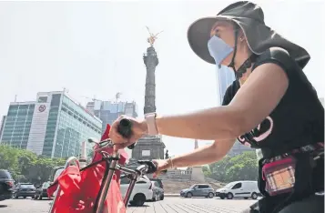  ??  ?? Capitalino­s que tuvieron que salir a laborar o a la escuela se protegiero­n con tapabocas, sombreros y bloqueador solar para mitigar la contingenc­ia ambiental y el calor intenso de la tarde.