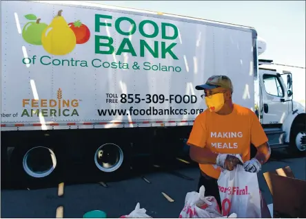  ?? PHOTOS BY JOSE CARLOS FAJARDO — STAFF PHOTOGRAPH­ER ?? Food Bank of Contra Costa and Solano volunteer Esteban Anfoso of Chico packages food as a truck arrives during a food distributi­on event.