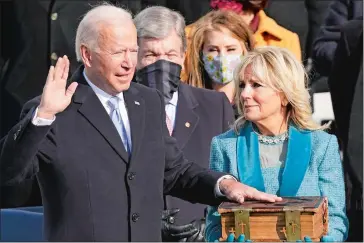  ?? ANDREW HARNIK/AP PHOTO ?? Joe Biden is sworn in by Chief Justice John Roberts as Jill Biden holds the Bible during the inaugurati­on.