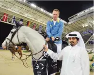  ??  ?? Germany’s Christian Ahlmann, astride Caribis Z, poses with Qatar Racing and Equestrian Club general manager Nasser Sherida al-Kaabi after winning the CSI 5* Against-the-clock with jump-off 1.50/1.55m event at Al Shaqab Arena yesterday.