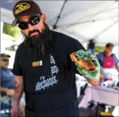  ??  ?? Chef Ben Beltran of the Big Boys Barbecue booth holds a tender rib made during the Brawley Elks Lodge’s second annual Oktoberfes­t Rib Cook-Off held Saturday afternoon on South Plaza Street in Brawley. PHOTO VINCENT OSUNA