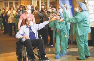  ?? Brian A. Pounds / Hearst Connecticu­t Media ?? Retired surgeon John Famigliett­i, 71, of Brookfield, is cheered by Danbury Hospital staff as he is released Wednesday after winning a seven-week battle with COVID-19.