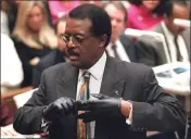  ?? VINCE BUCCI - AFP - GETTY IMAGES ?? Defense lawyer Johnnie Cochran Jr. puts on gloves while he addresses the jury during closing arguments in the O.J. Simpson double murder trial.