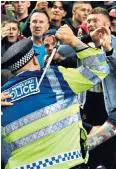 ??  ?? Flashpoint: A policeman confronts fans after a late goal is ruled out by VAR