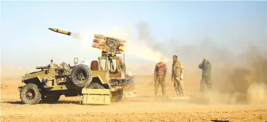  ?? (Thaier al-Sudani/Reuters) ?? SHI’ITE FIGHTERS fire a rocket towards Islamic State militants during a battle at the airport of Tal Afar, west of Mosul, in 2016.