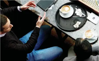  ?? Picture: REUTERS/Jason Cairnduff ?? RELAXING: Customers enjoy their coffee at a café. According to scientists, people who drink three to four cups of coffee a day are more likely to see health benefits than those who abstain.