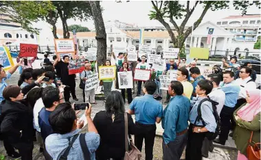  ??  ?? Making a stand: Khoo (centre, in red shirt) speaking to other NGO members at the protest in front of the state assembly building in Lebuh Light, George Town.