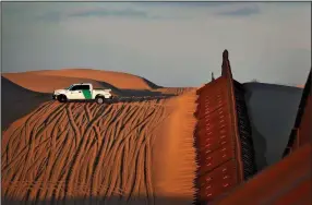  ?? AP/MATT YORK ?? A U.S. Customs and Border Patrol agent keeps watch near a section of border fence in Imperial County, Calif., in July.