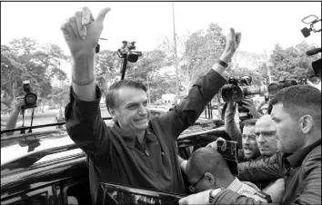  ?? LEO CORREA / ASSOCIATED PRESS ?? Presidenti­al frontrunne­r Jair Bolsonaro, of the Social Liberal Party, flashes thumbs up to supporters Sunday after voting at a polling station in Rio de Janeiro, Brazil.