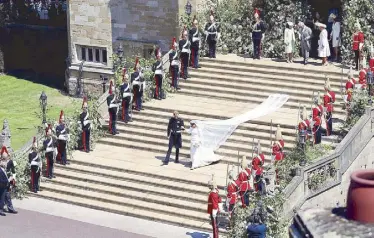  ?? AFP ?? The Duke and Duchess of Sussex walk down the west steps of St. George’s Chapel.