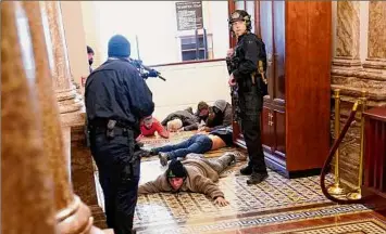  ?? Andrew Harnik / Associated Press ?? In this Jan. 6 photo, U.S. Capitol Police hold rioters at gunpoint near the House Chamber inside the U.S. Capitol in Washington.