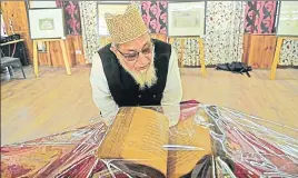  ??  ?? ■ A visitor looks at the Quranic manuscript on display at the Tourist Reception Centre in Srinagar on Saturday. WASEEM ANDRABI/HT