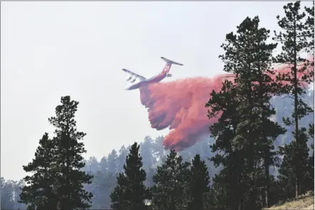  ?? MATTHEW BROWN/AP ?? AN AIRCRAFT DROPS FIRE RETARDANT TO SLOW THE SPREAD of the Richard Spring fire, east of Lame Deer, Mont., on Wednesday. The fire spread quickly Wednesday as strong winds pushed the flames across rough, forested terrain.