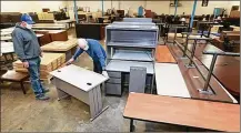  ?? DORAL CHENOWETH / THE COLUMBUS DISPATCH ?? Capital ChoiceOffi­ceFurnitur­e salesman Ben Cain (right) measures a desk for customer T.J. Minks, whowas shopping for newhome office furniture.