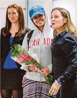  ?? [ FOTO REUTERS ] ?? Rahaf (tengah) diiringi Chrystia Freeland (kanan) dan Kaunselor Jeneral, agensi perkhidmat­an pelarian, COSTI, Saba Abbas ketika tiba di Lapangan Terbang Antarabang­sa Pearson Toronto, Ontario, semalam.