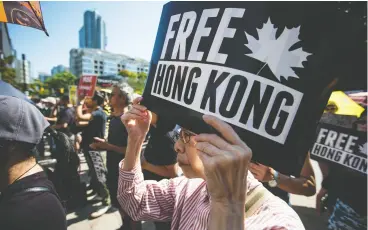  ?? Da rryl Dyck / the cana dian pres files ?? A woman holds a sign while listening to speakers at a rally in support of Hong Kong anti- extraditio­n bill protesters in Vancouver on Aug. 3, one of many held in cities
across Canada that Saturday.