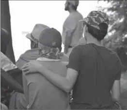  ??  ?? Children supporting each other during the moment of remembranc­e at Camp Erin in Hamilton.